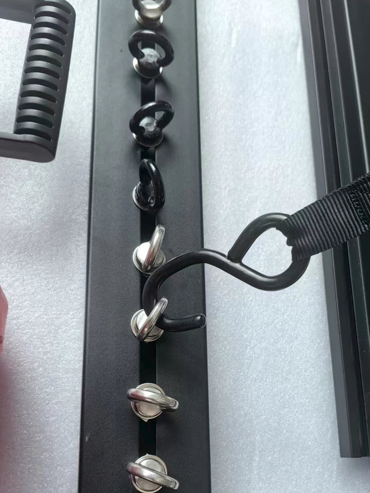 Strap hooked to eye bolts in a roof rack T-slot