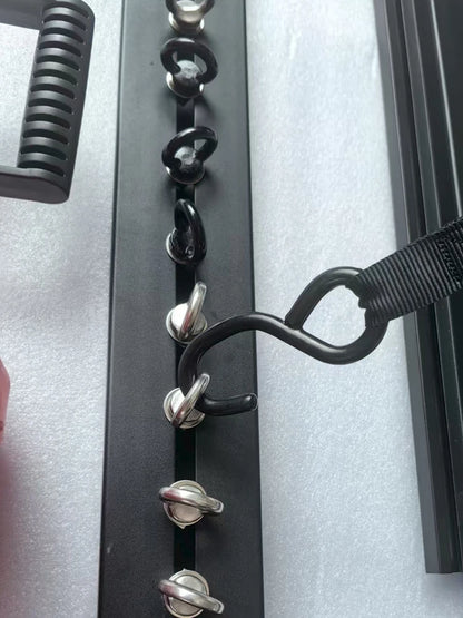 Strap hooked to eye bolts in a roof rack T-slot