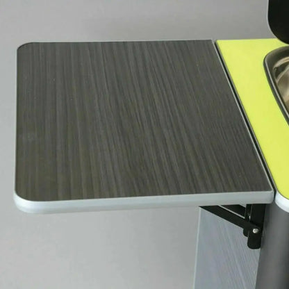 Fold-down table top mounted on folding brackets in a camper