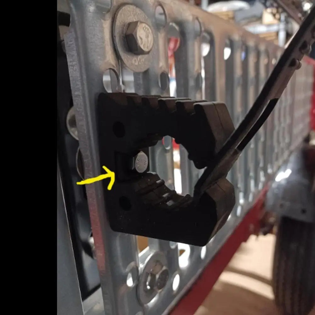 Rubber tool clamp mounted on a grille holding a bar