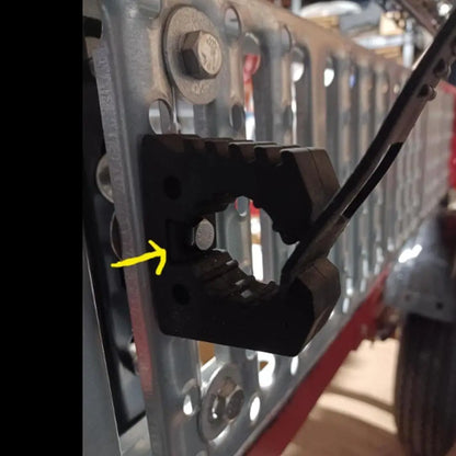 Rubber tool clamp mounted on a grille holding a bar